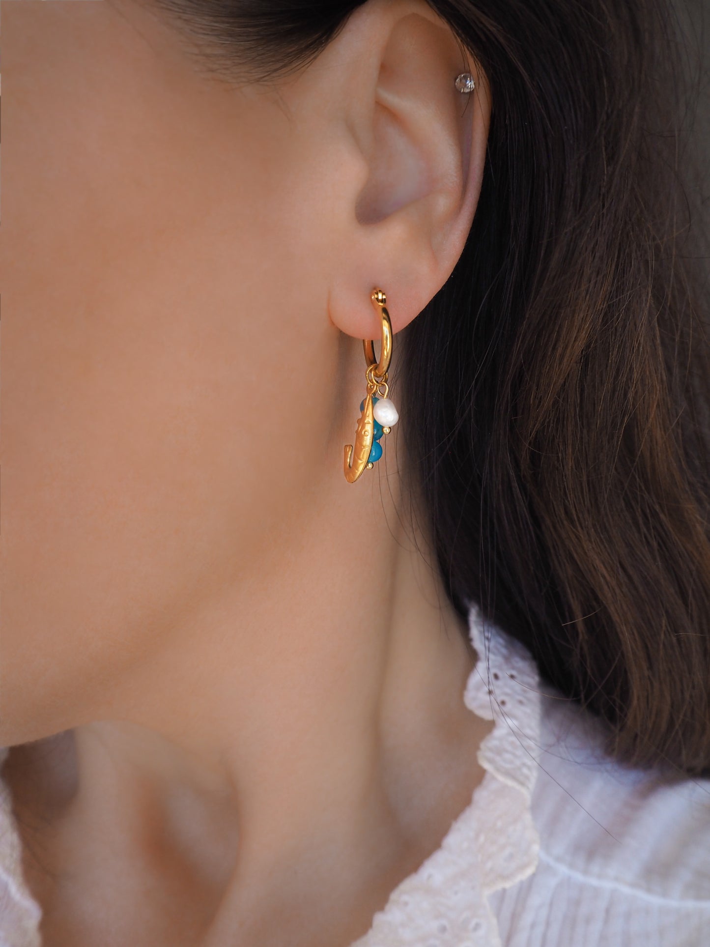 Model wearing Blue Shrimp Trio Gold Earrings with pearls and aquamarine gemstones