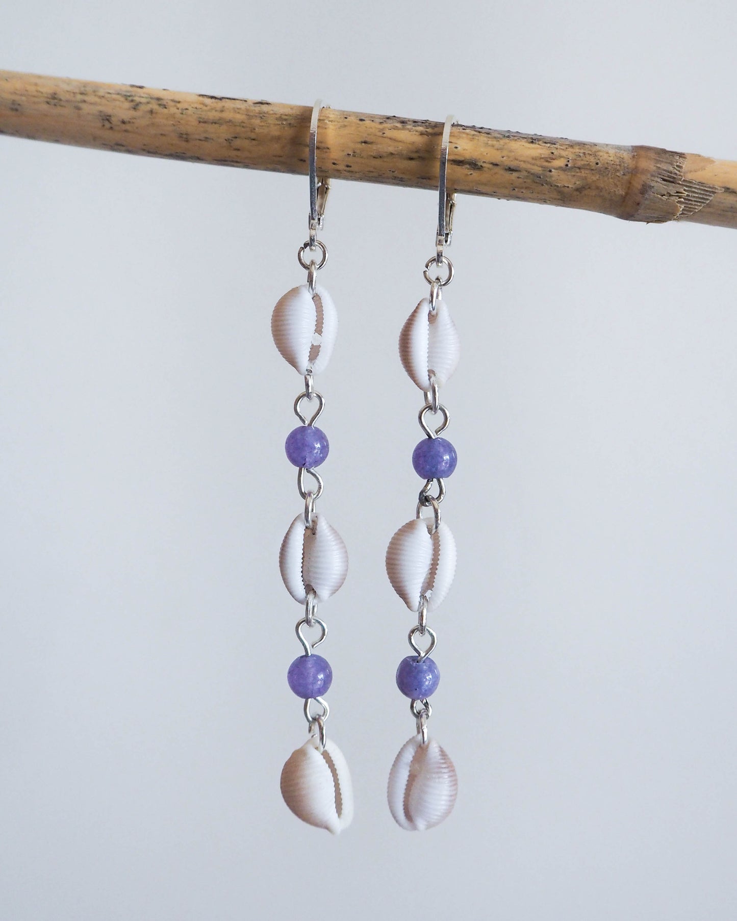 Close-up of European Cowrie Shell Earrings with Amethyst Bead Accents