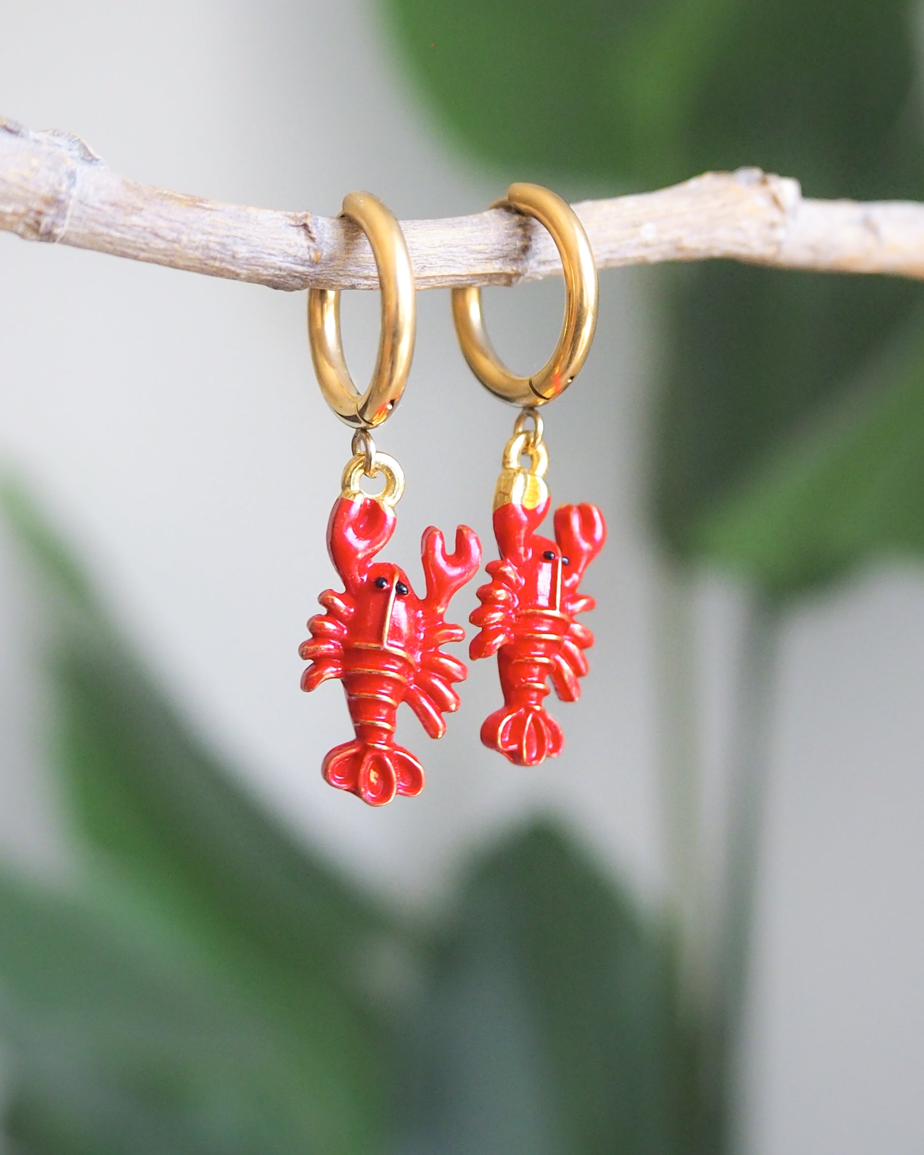 Front view of red lobster gold earrings