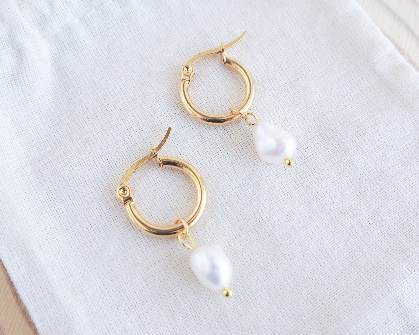 Gold Ivory White Pearl Earrings on display