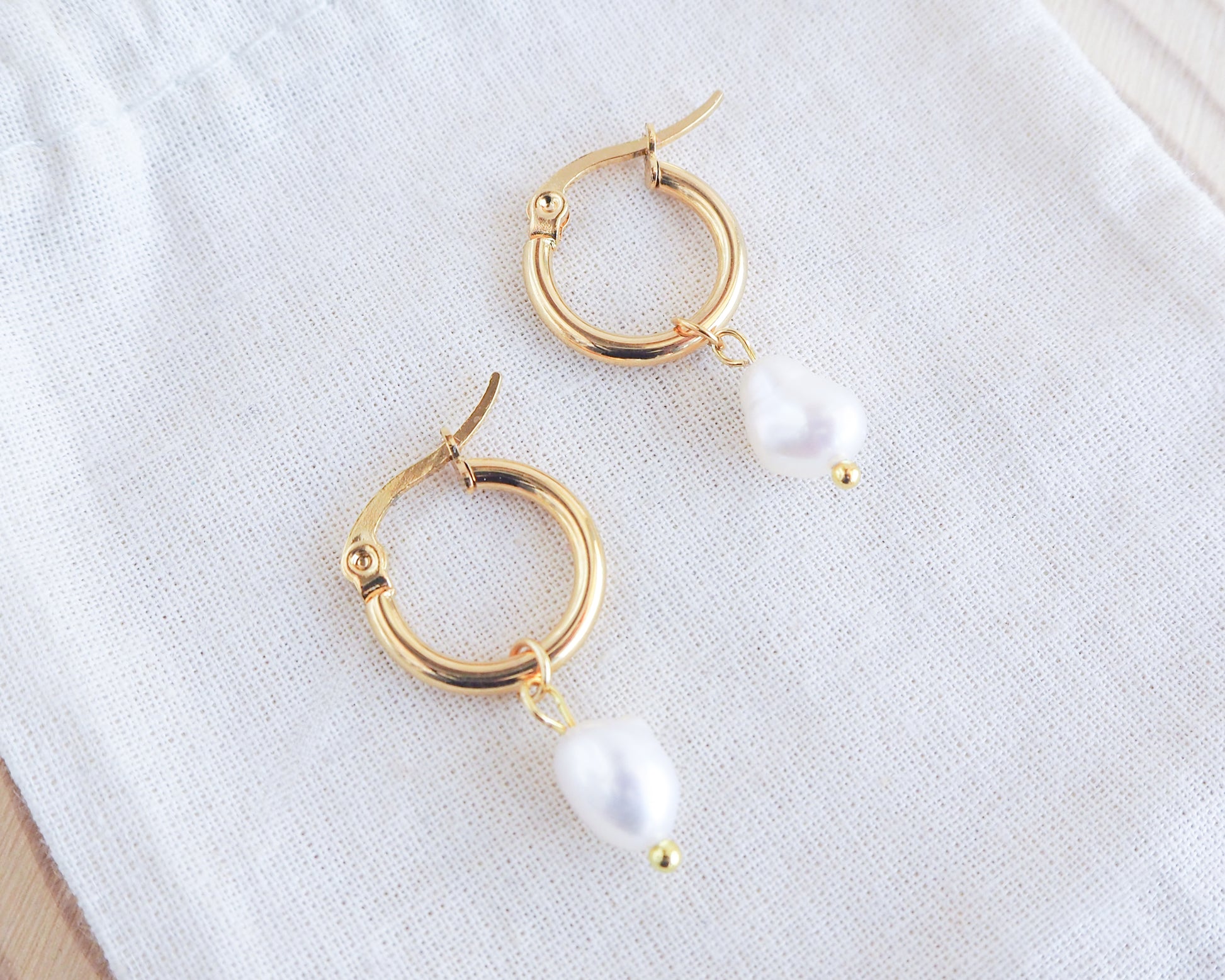 Gold Ivory White Pearl Earrings on display