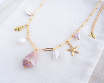 Gold Ocean Shell Charm Necklace side view, with cone and cowrie shells, freshwater pearls, starfish sea star shell pendants. 