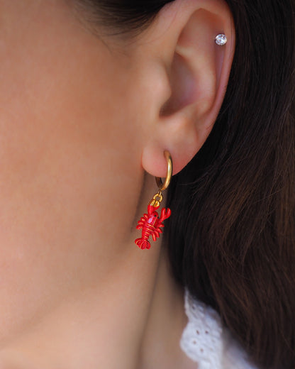 Model wearing red lobster gold earrings