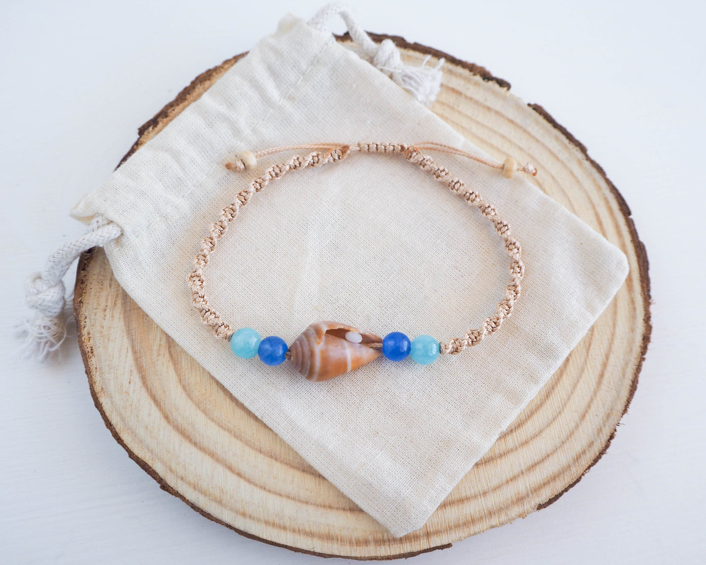 Handcrafted Beach-inspired Bracelet featuring Cone Shell, Gold Cord, and Aquamarine Beads