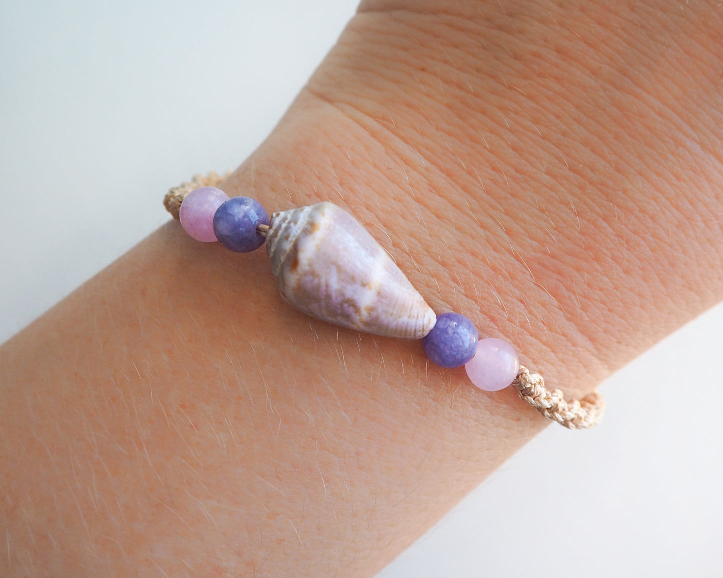 Model wearing Real Cone shell bracelet with rose quartz and amethyst beads