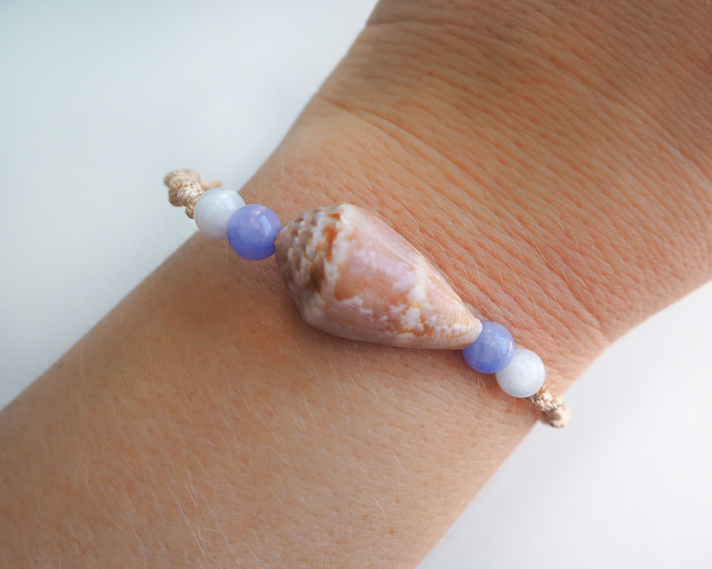 Handcrafted Beach-inspired Bracelet featuring Cone Shell, Gold Cord, and Angelite Quartz Beads