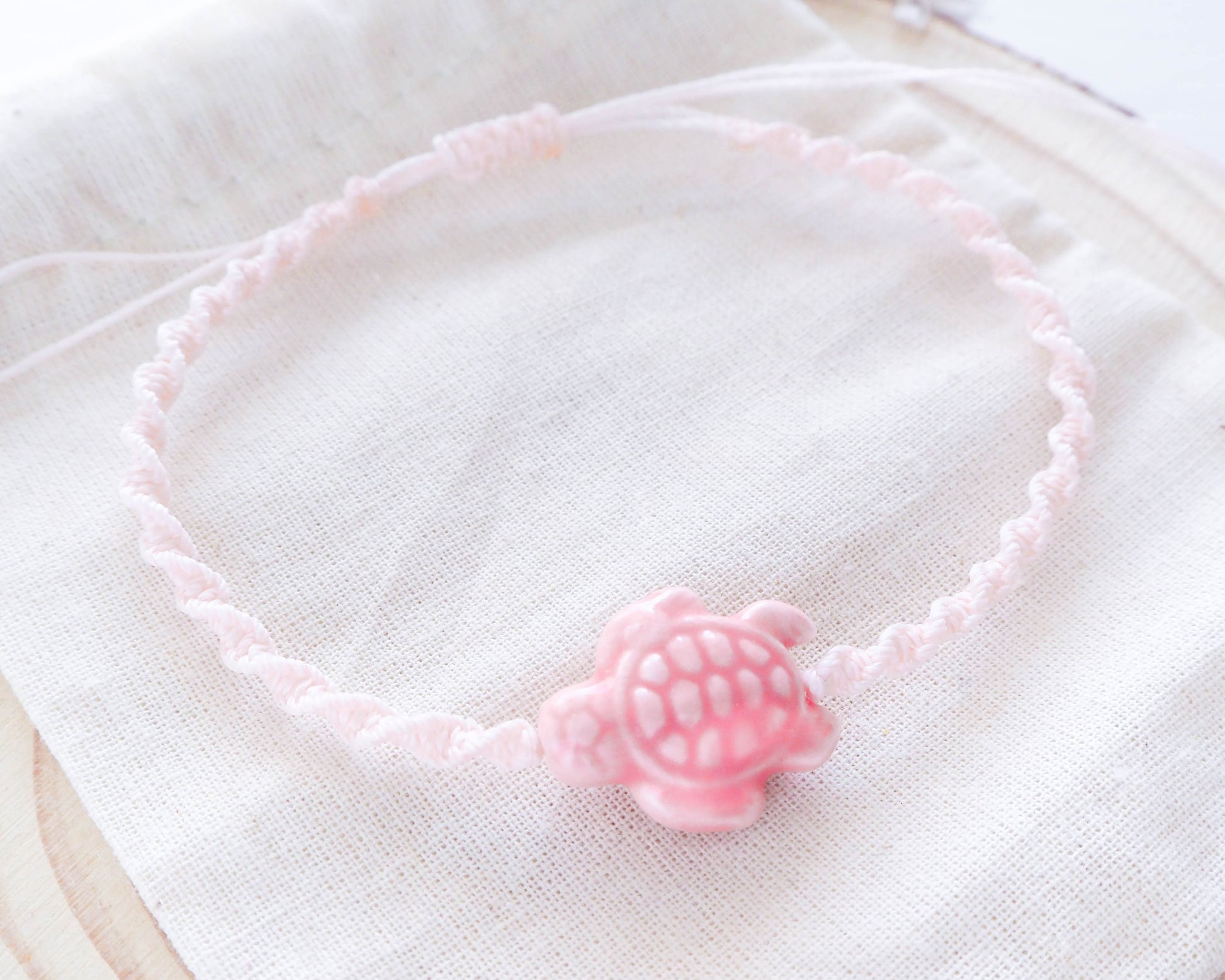 A high-resolution image showcasing the braided band of the Soft Pink Ceramic Turtle Braided Bracelet. The band is earthy and textured, creating a harmonious contrast with the ceramic turtle.