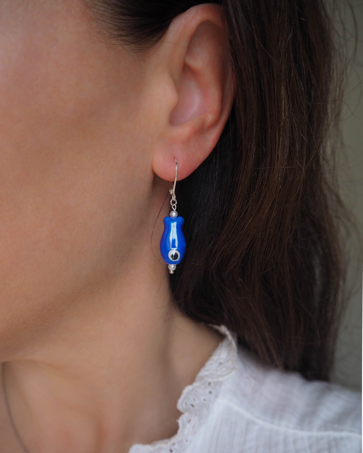 Model wearing Sardine Earrings, Blue Ceramic Sardine Earrings, Handcrafted Sardine-shaped Jewelry