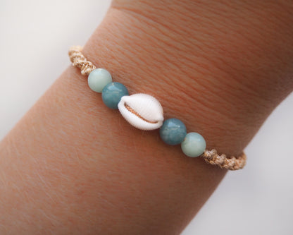 A wrist adorned with the stylish Portuguese Cowrie Shell Bracelet, a fusion of cultural allure and natural beauty