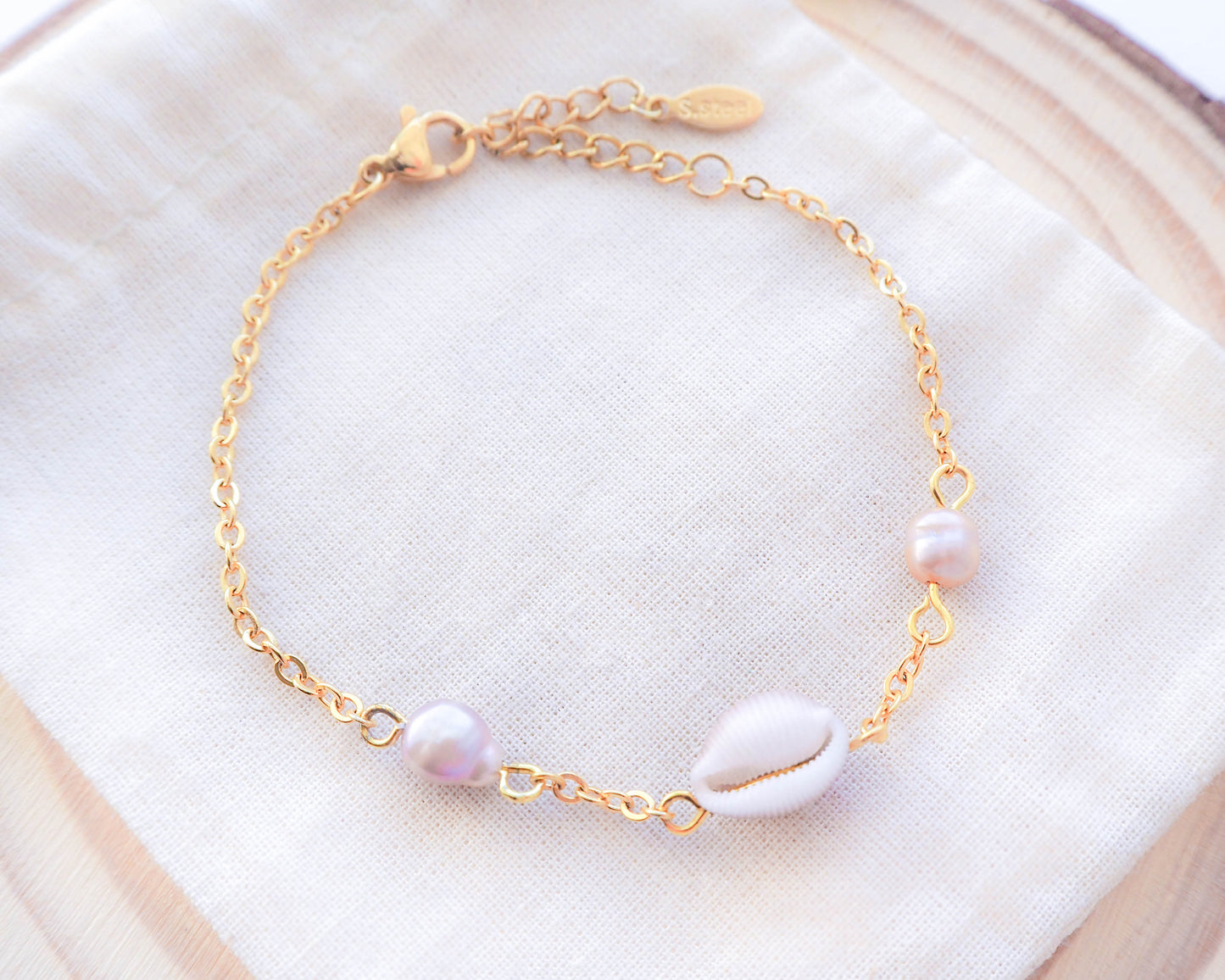Close-up of Cowrie Shell and Freshwater Pearl Bracelet on Gold Chain