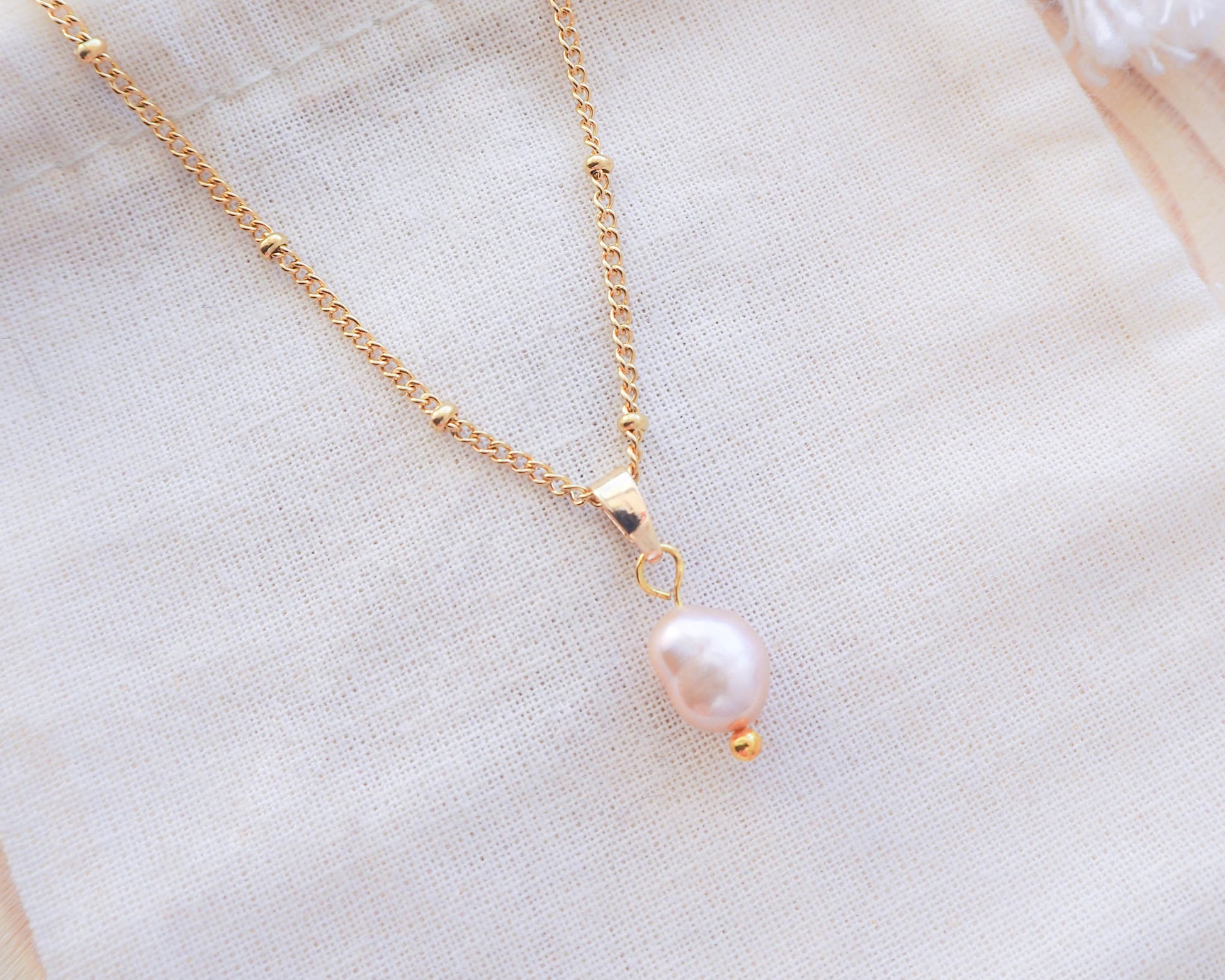 Close up of Sea by Lou Gold Necklace with rose color freshwater pearl pendant 