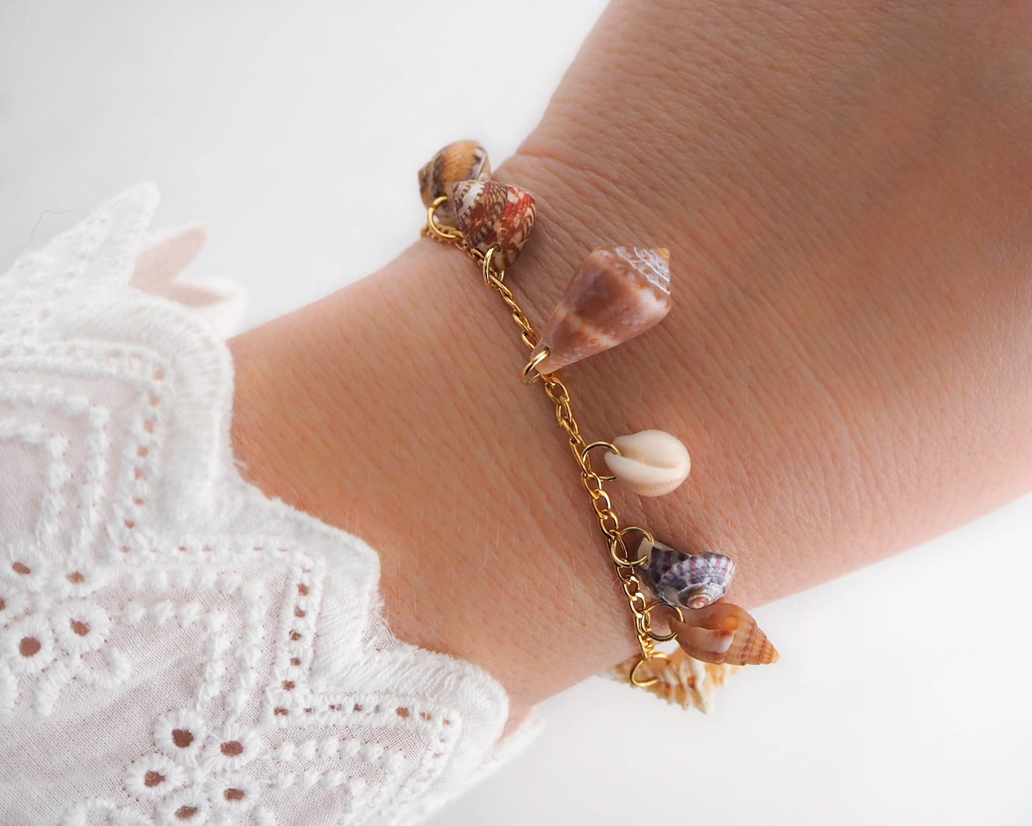 Model wearing Gold Shell Charm Bracelet with 7 Tiny Shells: ocean-inspired jewelry from Portugal
