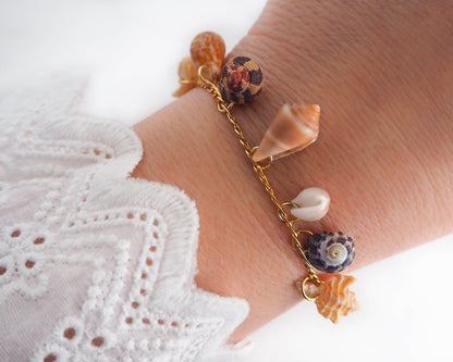 Model wearing Gold Shell Charm Bracelet with Tiny Shells: ocean-inspired jewelry from Portugal - SEABYLOU