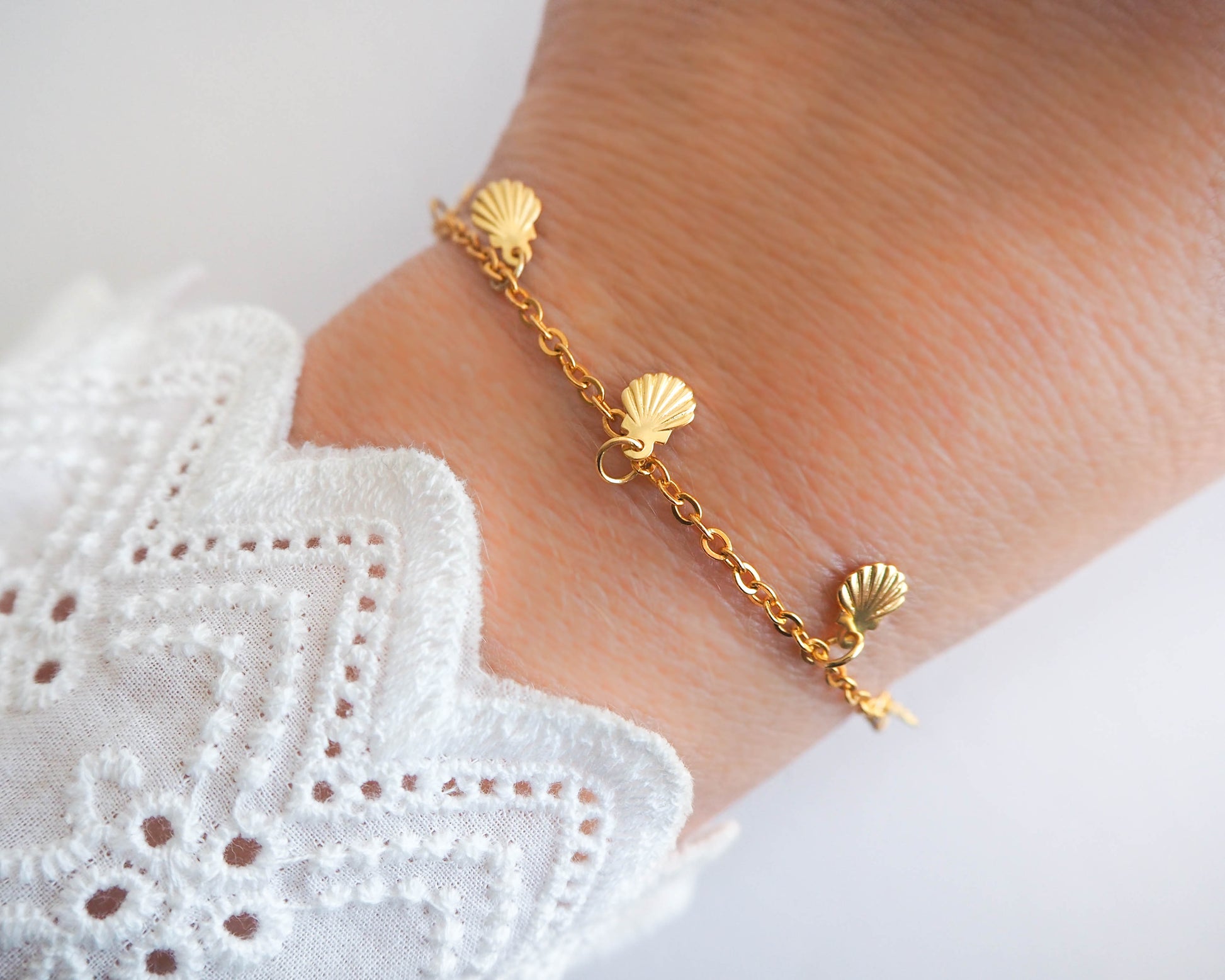 Model wearing Golden Charm Bracelet with tiny Shell pendants, seabylou, sea by lou