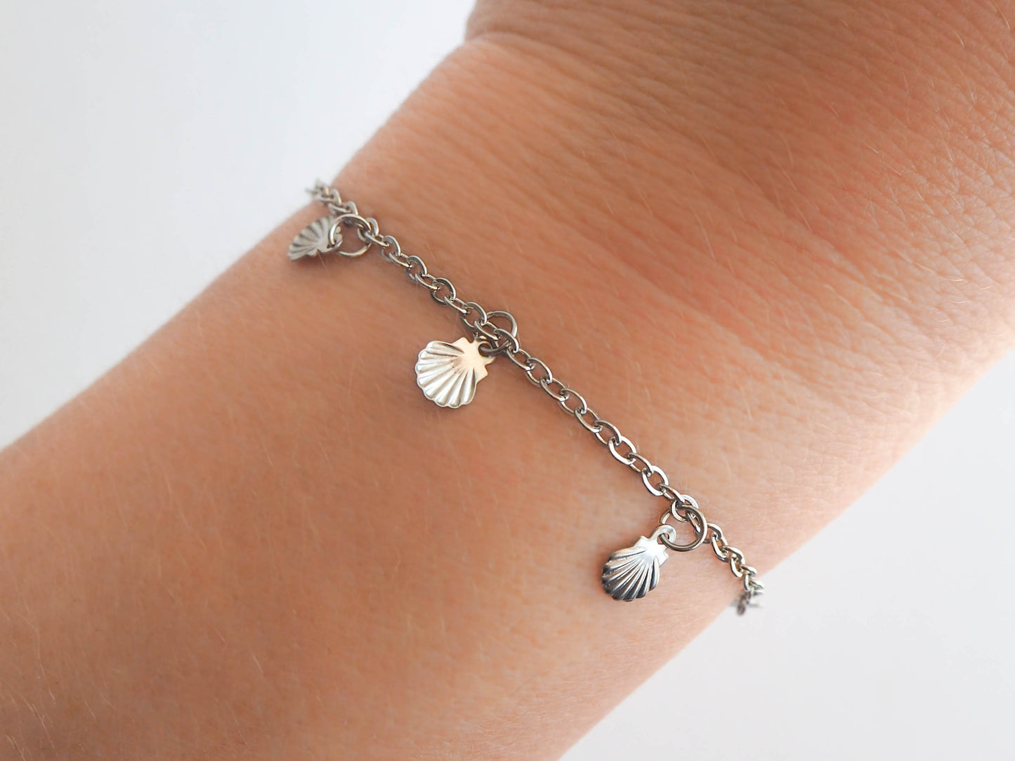 Model wearing Silver Charm Bracelet with tiny Shell pendants
