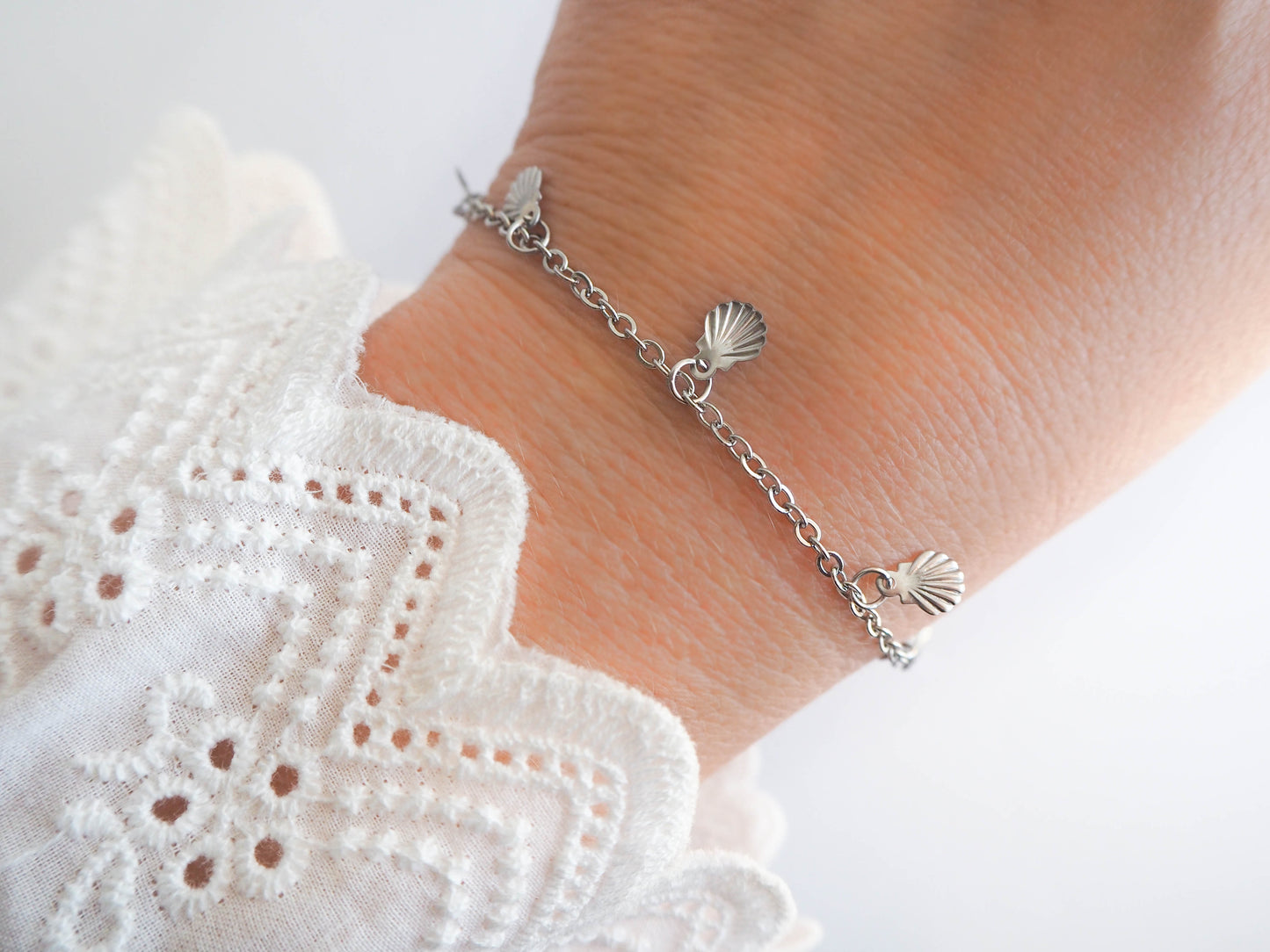 Silver Tiny Charm Bracelet on model. Bracelet with tiny Shell pendants