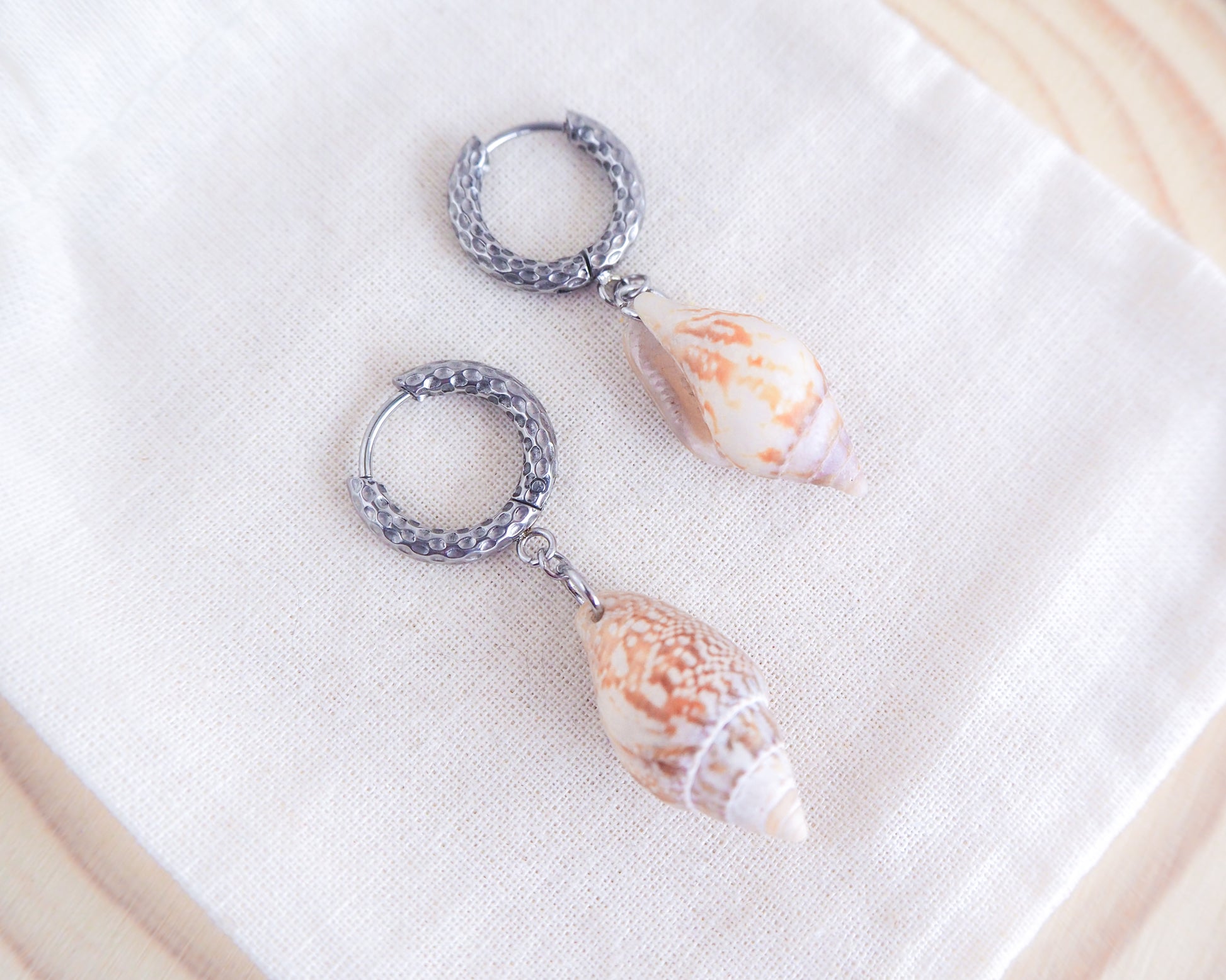 Rustic Dove Shell Earrings with Silver Hoop Hooks on display
