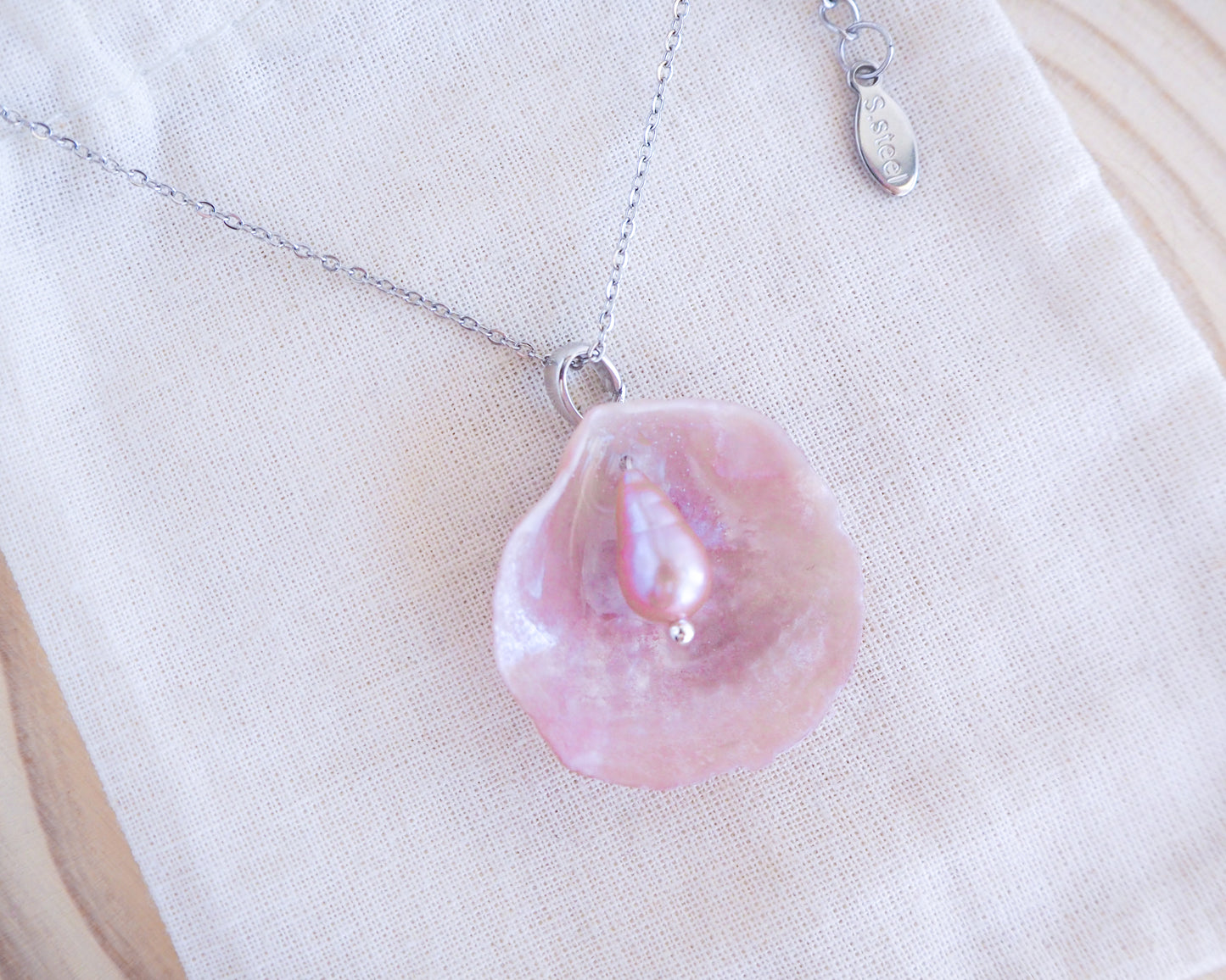Pink Jingle Shell Silver Necklace with freshwater pearl, Mother of Pearl Pendant on display