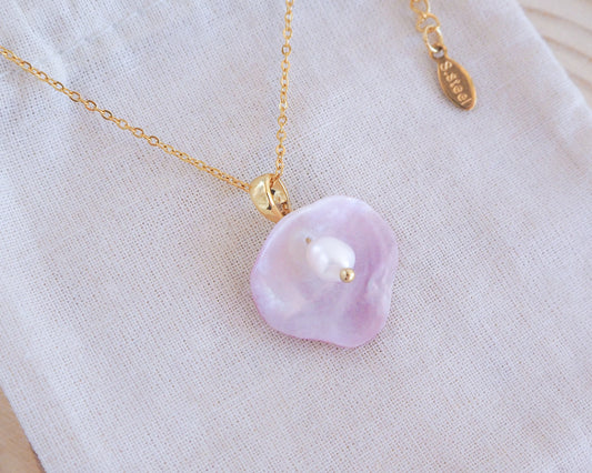 Soft Pink Jingle Shell Gold Necklace with White Freshwater Pearl on display