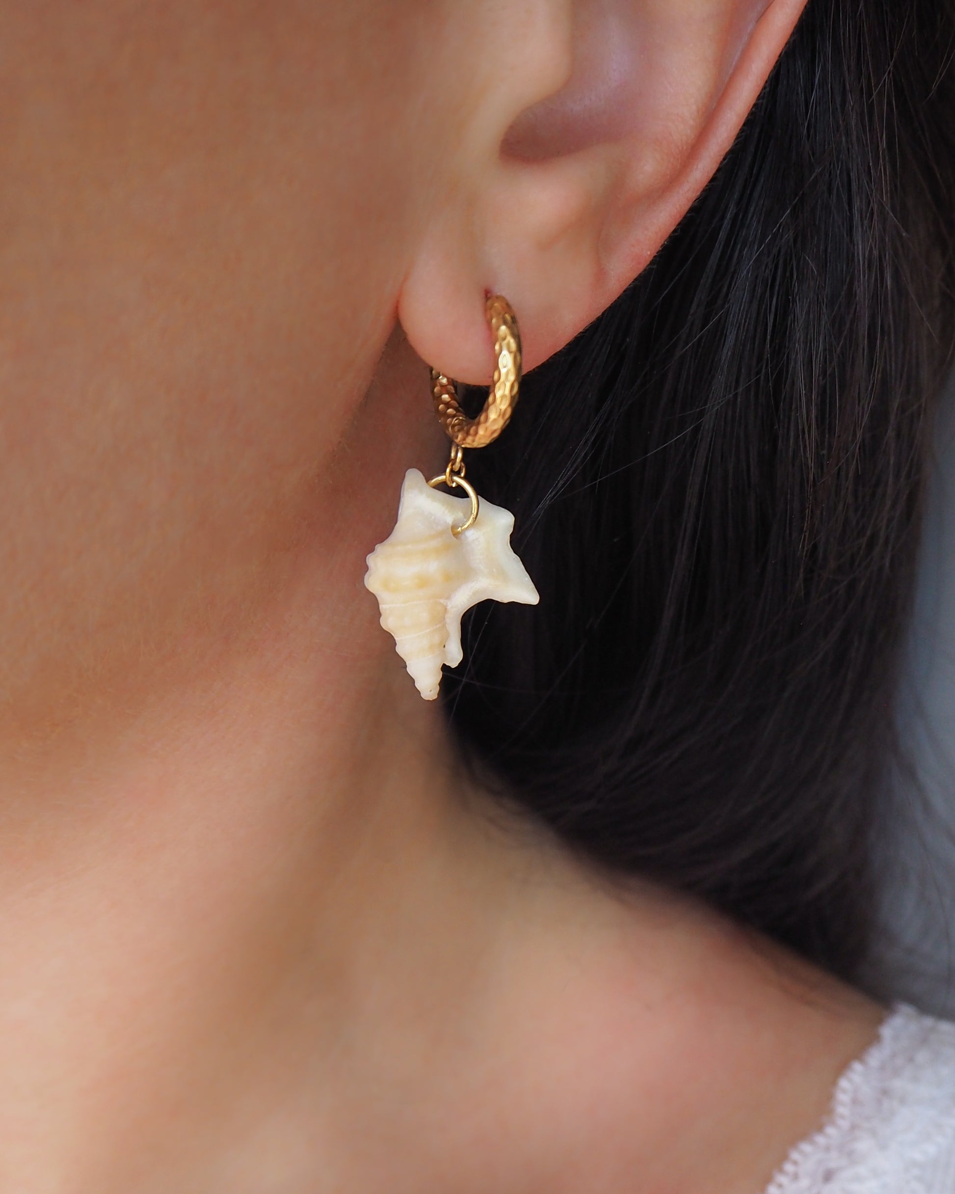 Gold Pelican's Foot Shell Earrings on model