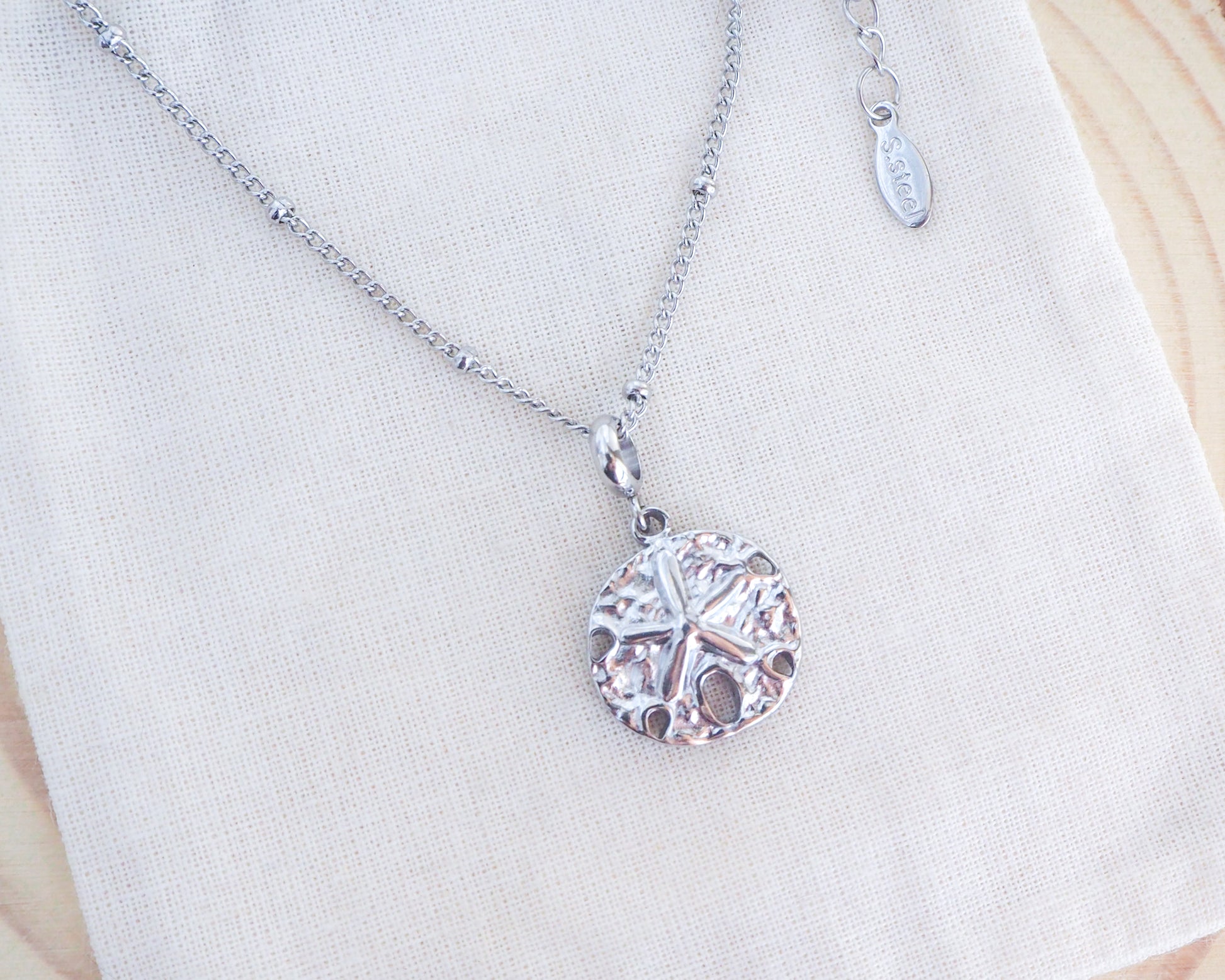 Silver Sand Dollar Necklace on display