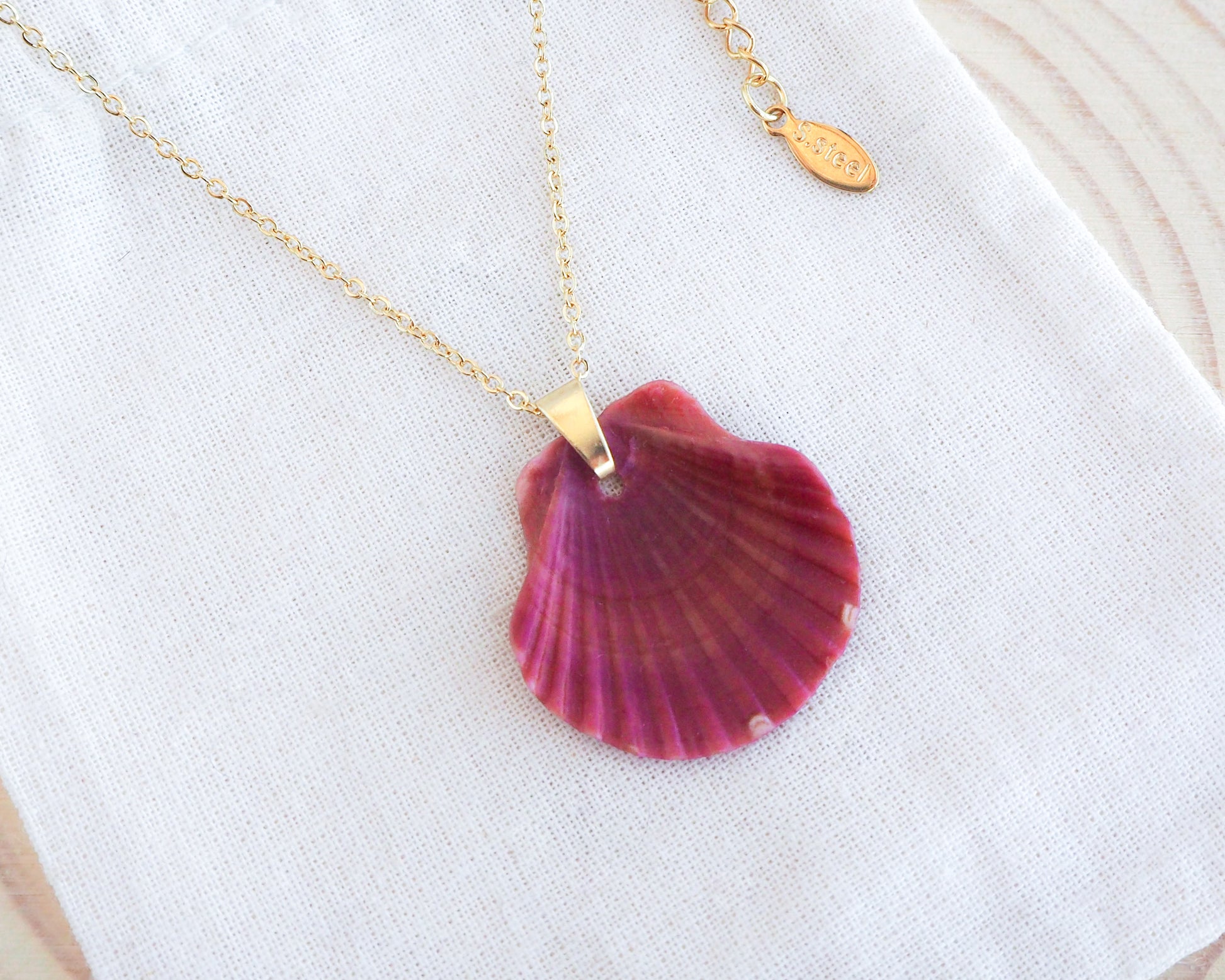 Red Scallop Shell Gold Necklace on display